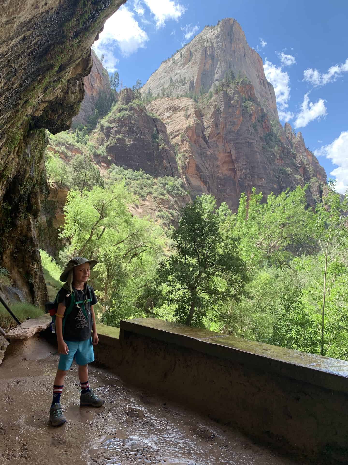 Boy standing in front of Weeping Rock in Zion National Park